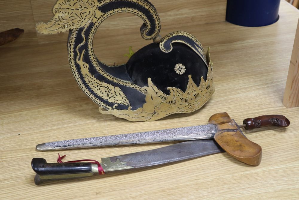 A 19th century Javanese kris, with 14 inch blade, two other edged weapons and a ceremonial head-dress